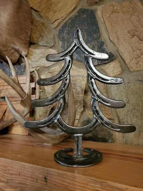 Make your home both rustic and seasonal this Christmas with this handmade horseshoe tree! Also makes a great gift for friends or family. Horseshoe Diy Projects, Horse Shoe Christmas Tree, Welding Projects Christmas, Horse Show Welding Projects, Horse Shoe Nail Crafts, Christmas Welding Projects Gift Ideas, Horse Shoe Welding Art Ideas, Horseshoe Christmas Decorations, Horseshoe Welding Ideas