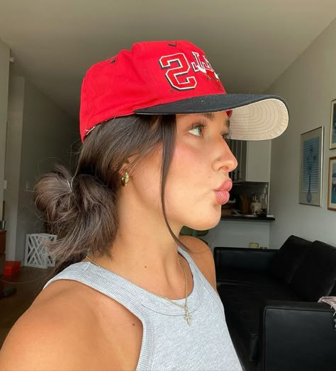 On the days when you want to do something a little more with your 'do, we've got you covered with four hairstyles to elevate your hat look. PC: @arud_ on Instagram Hair Up Hat Styles, Women In Hats Baseball Caps, Hair Ideas For Hats Style, Bun And Hat Hairstyles, Cute Hairstyles With Trucker Hat, Hairstyle In Hat, Trucker Hat Curly Hair, Updo Hat Hairstyles, Women’s Hat Hairstyles