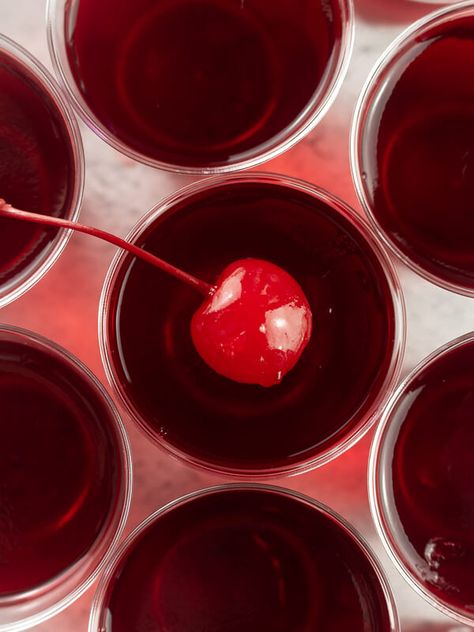 These cherry bomb jello shots are so good and perfect for your next party! These shots are so full of flavor- made with cherry Jello, cherry vodka, red bull, and grenadine. Top them with a maraschino cherry to make them extra delicious and cute! Red And Gold Jello Shots, Signature Shots Alcohol, Red Themed Snacks, Red 60th Birthday Ideas, Cherry Party Aesthetic, Jello Shots Aesthetic, Jello Shots Birthday, Cherry Dinner Party, Dirty Shirley Birthday Theme