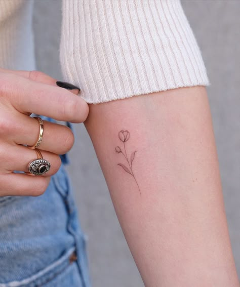 30 Meaningful and Beautiful Tattoo Ideas For Women - Flymeso Blog Tiny Tattoo Flower, Single Flower Tattoo Designs, Fineline Tulip Tattoo, Tattoo Ideas Tulip, Tulip Fine Line Tattoo, Tiny Tulip Tattoo, Small Tulip Tattoo, Single Line Flower Tattoo, Small Fine Line Tattoo Women