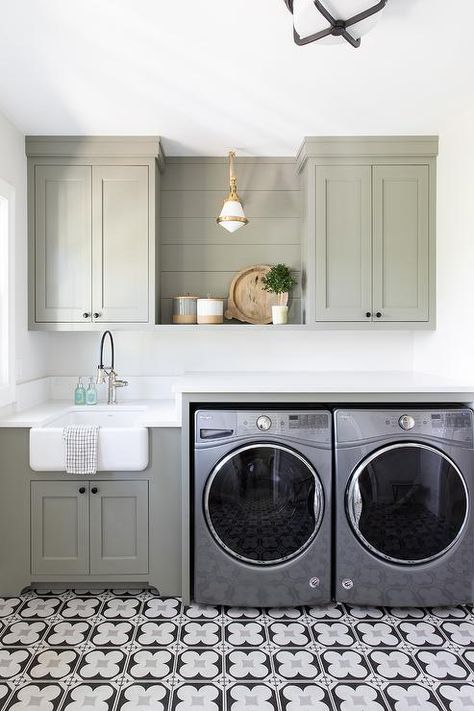 A silver front loading washer and dryer is placed on white and gray mosaic floor tiles and enclosed beneath a white countertop. Kate Marker Interiors, Green Laundry, Room Storage Diy, Dream Laundry Room, Basement Laundry, Laundry Room Renovation, Laundry Room Shelves, Laundry Room Cabinets, Laundry Room Remodel