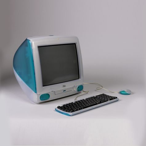 Egg-shaped computer/monitor unit (a) of translucent clear and blue plastic, with screen, CD drawer and two small speakers at front; carry handle inset in top rear; retractable blue foot bar on underside at front.  Two accompanying components are also of translucent clear and blue plastic: one, a flat rectangular keyboard (b) with black keys, retractable foot bar and cord; the other, a circular mouse with cord (c). Imac G3, Alter Computer, Imac Desk Setup, Old Computer, Shingle Colors, The Oregon Trail, Computer History, Small Speakers, Tech Branding