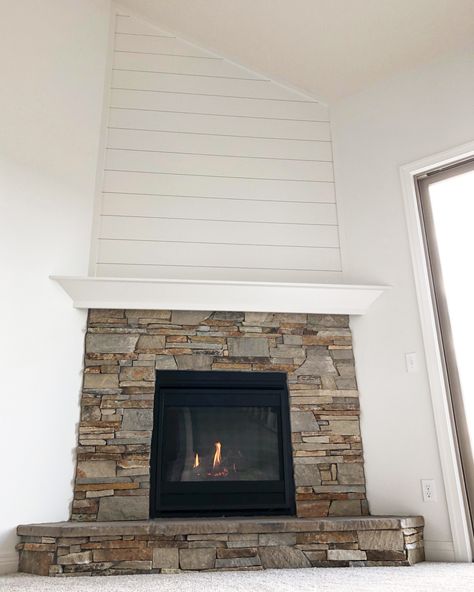 Heatilator direct vent gas fireplace with a real stone surround. The mantel is site built with shiplap above the mantel to the ceiling.  #shiplap #stonefireplace #gasfireplace #fireplacedecor #fireplace #homedecor Shiplap Above Stone Fireplace, Stone Fireplace With Shiplap Above, Shiplap Over Stone Fireplace, Corner Fireplace With Shiplap, Stone Shiplap Fireplace, Shiplap Stone Fireplace, Corner Fireplace Shiplap, Stone Fireplace With Shiplap, Fireplace With Shiplap Above