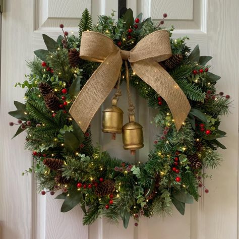 Made to Order Classic Pine Wreath with Bells: This classic pine wreath is perfect for Christmas, and all through winter! This pine wreath has added details like pinecones, berries, eucalyptus leaves, and other artificial greenery. The wreath is topped with a velvet bow (choose your bow color from the options when checking out). The center of the wreath features two rustic style gold/brass bells (can vary between 3.5"-5" tall). *Silver bells can be added by request, send a message to inquire. Because this is a hand made wreath, made to order, there may be slight variations between the example and your wreath. Any differences would be minimal. If you have any specific requests, please message me. Wreath measures about 22- 24" in diameter when fully "fluffed" with all of the greenery added, a Wreath Bells Christmas, Bell Decorations Christmas, Classic Wreath Christmas, Christmas Wreath Ideas 2024, Using Bells In Christmas Decor, Christmas Wreath Rustic, Christmas Wreaths Bow, Wreath With Berries, Bow Christmas Wreath