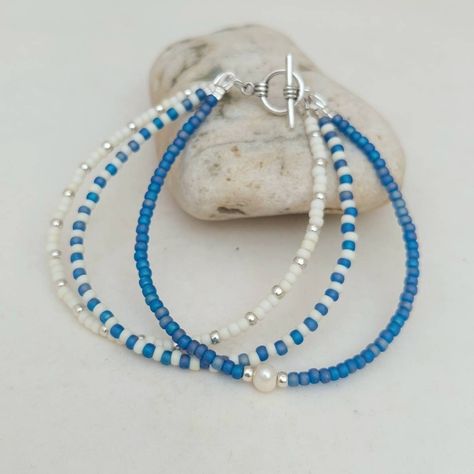 "This triple layer Cornish Blue Bracelet has been lovingly made using mixed patterns of Glass Seed Beads and detailed with a Freshwater Pearl. If the size you require is not showing, just send me a message and I will make one up for you. Threaded on strong 7 strand Tiger Tail wire and finished with wire guardians, and a toggle clasp. More Colours and Designs can be found at: https://www.etsy.com/uk/shop/CraftHutCornwall?section_id=31245004 Typical packaging as shown in images. I have carefully s Beach Seed Bead Bracelets, Cute Blue Beaded Bracelets, Fun Handmade Blue Beaded Bracelets, Fun Blue Beaded Bracelets, Cute Handmade Blue Beaded Bracelets, Cute Colorful Beaded Blue Jewelry, Sea Bead Bracelets, Blue Bracelet Beads, Blue Seed Bead Bracelet