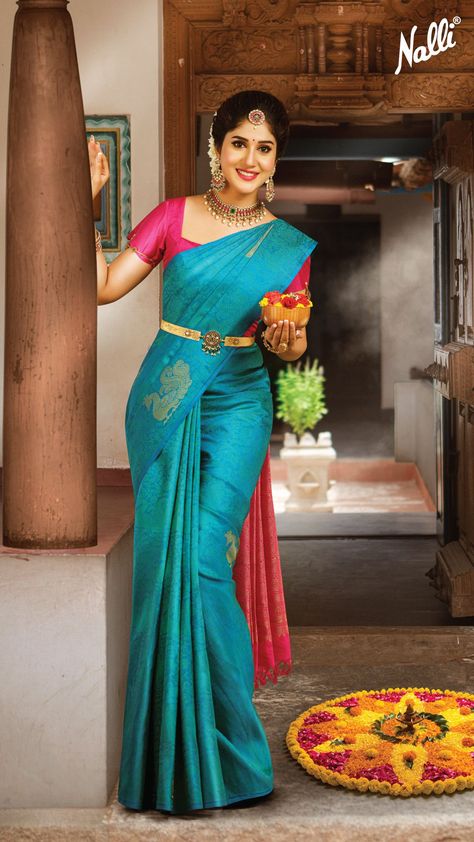 This navy blue Kanchipuram silk saree is woven in gold zari brocade all over the body, with a pink-colored zari-worked pallu and border. Match this saree with a contrast pink blouse, traditional jewelry, and a hair bun to complete the look. Navy Blue Bridal Party, Blue Bridal Party, Pink Saree Blouse, Saree Color Combinations, Pink Blouse Designs, South Indian Bride Saree, Blue Blouse Designs, Pink And Blue Dress, Blue Silk Saree