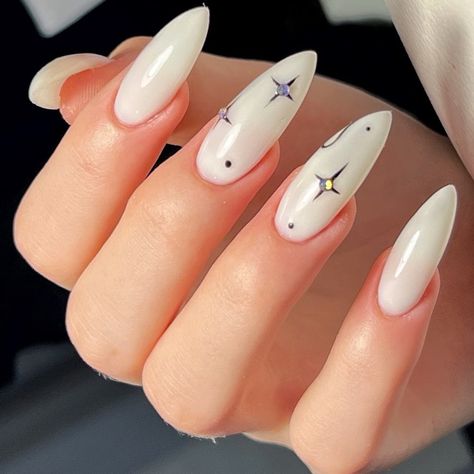 White Base Nail Design, White Background Nails, Cute White Nail Ideas Almond, White Nails With Planet Charm, White Nails With Moon Design, Almond White Nails Design, Unique White Nails, Black And White Celestial Nails, Black And White Star Almond Nails