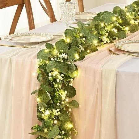 Gray-green faux garlands are a must-have centerpiece for your table. Artificial vine green leaves are made of high-grade silk and non-toxic plastic. Each leaf is printed with texture for an impeccably realistic look. The ombre garland also incorporates many soft white flowers, giving the entire vine a full, beautiful, layered look. They won't wilt or fade, and whether it's a wedding table or a family table, our high-quality vine garland will achieve the look you want! This enhanced eucalyptus le Leaf Centerpiece Wedding, Olive Green Table Decor, Spring Boho Wedding Decor, Runner Centerpieces Wedding, Dark Green Table Decor, Wedding Railing Decorations, Long Floral Arrangement For Table, Green And White Table Decor Wedding, Herb Table Decor