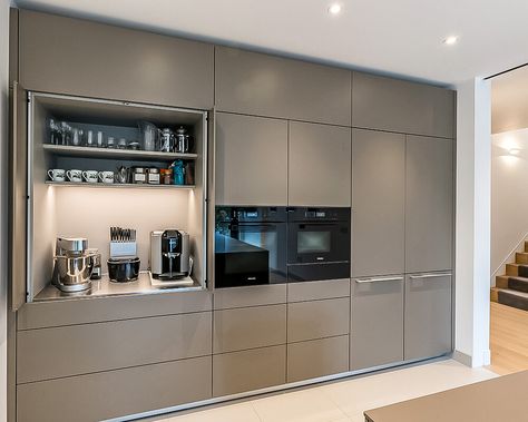 The tall bank of units has been specified and produced to fit perfectly across the wall space, from edge to edge. A shadow gap above is a nice design touch and ensures airflow around the appliances, allowing them to function correctly. A bulthaup b3 pocket door provides a useful space for small appliances and refreshment making items away from the main kitchen area. Above the main cupboard space, top box units take the cabinetry towards the ceiling, giving a wall-like appearance. Kitchen Tall Units, Kitchen Unit Designs, Bulthaup Kitchen, Kitchen Wall Units, Tall Kitchen Cabinets, Kitchen Appliance Storage, Kabinet Dapur, House Design Kitchen, Kitchen Design Decor