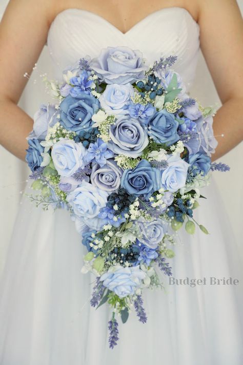 This lovely assortment of lavender, lilac, steel blue and periwinkle is bound to turn heads on your wedding day. This lovely cascading brides’ bouquet from the is an absolutely breathtaking arrangement for any bride to be, in any season. Lavender fronds and babies breath complete the look and add a delicate realism to this beautiful bouquet. This bouquet is 10” wide, 18” long, and is crafted by our in-house florists without using a foam base to anchor the flowers to the bouquet. Instead, we wire Navy Blue And Light Pink Wedding Centerpieces, Bridal Bouquet Forget Me Nots, Waterfall Bouquet Wedding Blue, Blue Winter Wonderland Wedding, Steel Blue Wedding Flowers, Dark And Light Blue Wedding, Dusty Blue Bride Bouquet, Flower For Wedding Bouquet, Light Blue Garden Wedding