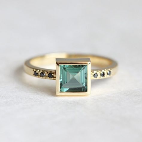 With a princess cut + black diamond side stones, this ring has endless edgy appeal that will go over big with any modern bride. Budget Friendly Engagement Rings, 18k Gold Engagement Ring, Handmade Engagement Ring, Tourmaline Engagement Ring, Bijoux Art Nouveau, Engagement Rings Princess, Green Tourmaline Ring, Handmade Engagement Rings, Gold Diamond Wedding Band