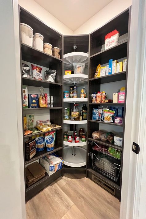 This photograph is looking into a walk-in pantry closet that has been upgraded to have a custom organization system installed in our vintage rio finish. This pantry design includes adjustable shelves, pull-out wire baskets of two sizes. It also has a Lazy Susan and toe kicks that push a floor vent forward so that the air to the room isn't impeded by the system. Mini Walk In Pantry Ideas, Large Corner Pantry Walk In, Walk In Pantry Wire Shelving, Kitchen Lazy Susan Ideas Corner Pantry, Angled Pantry Ideas, Corner Pantry Built In, Lazy Susan Pantry Organization, Corner Shelves Pantry, Triangle Pantry Organization