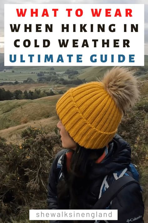 What to wear when hiking in cold weather ultimate guide, written by she walks in England. There is a photo of Zoe wearing a yellow wool bobble hat, with a back drop of countryside hills and fields. Cold Weather Hiking Gear, 9 Degree Weather Outfit, Cold Weather Hike Outfit, Hiking Outfit By Temperature, Hiking In Cold Weather Outfit, Cold Hike Outfit, Cold Weather Hiking Outfits For Women, Hiking Cold Weather Outfit, What To Wear For Hiking