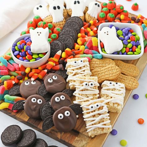 This colorful Halloween Snack Board is a delicious and festive mix of our favorite Halloween treats. Your party guests will have a wickedly good time munching on this fun presentation of candy, cookies and other sweet snacks. Halloween Snack Board, Pelottava Halloween, Halloween Themed Snacks, Chocolate Covered Raisins, Dulces Halloween, Halloween Snack, Food Bars, Colorful Halloween, Halloween Movie Night