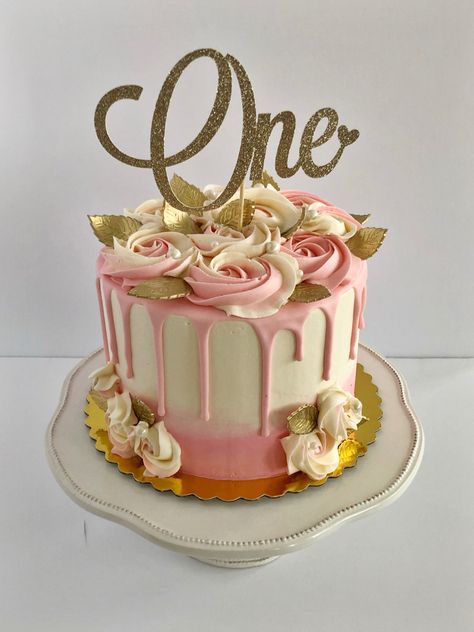 Pink to white gradient cake. Pink drip. Rosettes act as roses and there are gold leaves made from gum paste. In the middle there is a gold and sparkly cake topper that says “One”. Pink And Rose Gold Cake, Cake For One Year Old, Birthday Cakes For Mom, Pink Drip Cake, Birthday Cake Roses, Cake Roses, Rose Gold Cake, One Year Old Birthday, Caked Up