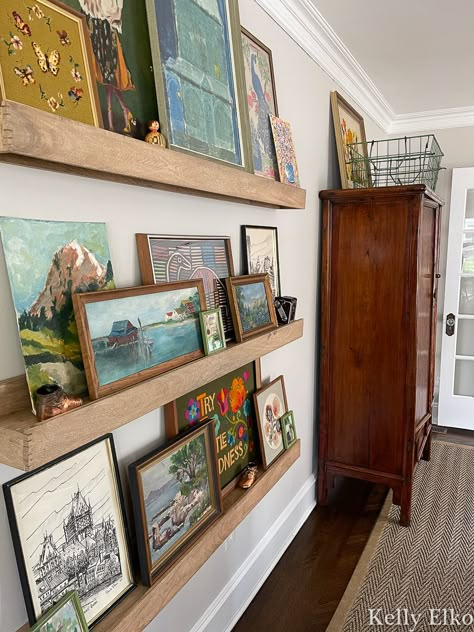 Pictures Of Artists At Work, Wall Art On Shelves Picture Ledge, Picture Ledges Living Room, Natural Gallery Wall, Wall Picture Ledge Ideas, Picture Ledge Above Piano, Picture Wall Ledge, Living Room Layout Couch Not Against Wall, Picture Ledge Wall Hallway