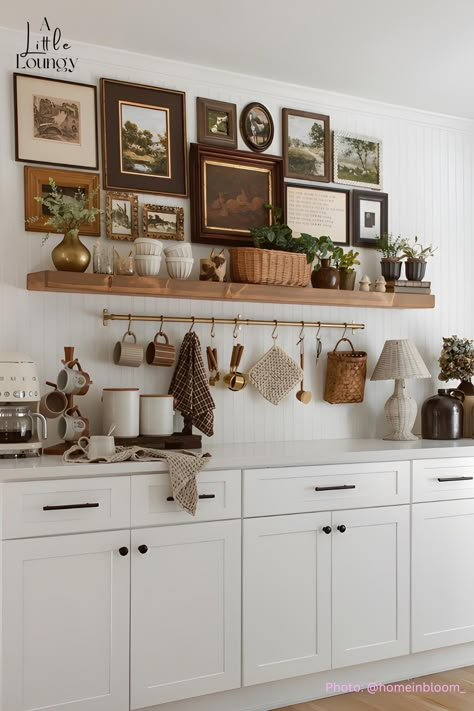 vintage-inspired art is the showcase of this stunning coffee bar! And, a metal hanging rack is always a great addition to a counter coffee bar for essentials like mugs, spoons, and dish towels. Vintage Decor Above Kitchen Cabinets, Coffee Bar Hanging Mugs, Pot And Pan Display Ideas, Kitchen Wall Display Ideas, Kitchen Wall Styling, Kitchen Buffet Table Ideas Decor, Floating Wood Kitchen Shelves, Stove Top Decor Ideas, Coffee Bar Gallery Wall