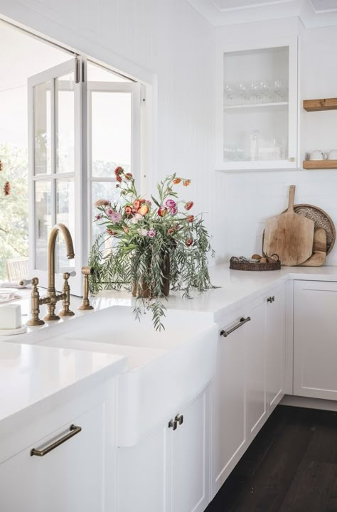 The white country shaker-style kitchen in this Queensland homestead is lifted by lots of light and fresh flowers. Federation Style Kitchen, Australian Country Kitchen, Queenslander Homes Interior Kitchens, Queenslander Kitchen Renovation, Country Style Homes Interior, Country Coastal Kitchen, Modern Queenslander Kitchen, White Queenslander, Federation Kitchen