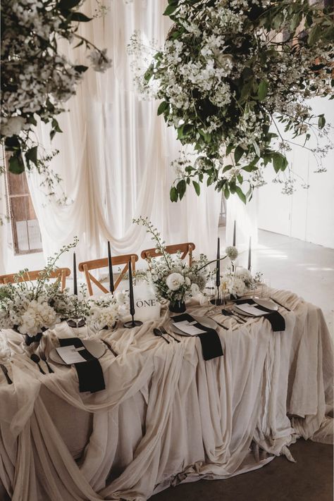 Chic minimal wedding inspiration with fabric hangings and gyposhilia white flower. Chic wedding table Black White Table Setting, Wedding Table White, Retro Wedding Cakes, Chic Wedding Table, White Table Setting, Black White Table, White Table Settings, Black Taper Candles, Vegan Wedding