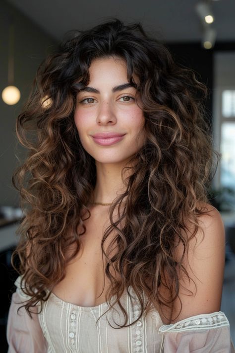 Smiling woman with long, curly hair wearing an off-shoulder top indoors. Butterfly Layers On Curly Hair, Curtain Bangs With Natural Curly Hair, Curly Butterfly Cut, Trendy Curly Haircuts, Long Layers Curly Hair, Type 2 Hair, Shaped Haircut, Butterfly Haircuts, Layer Haircut