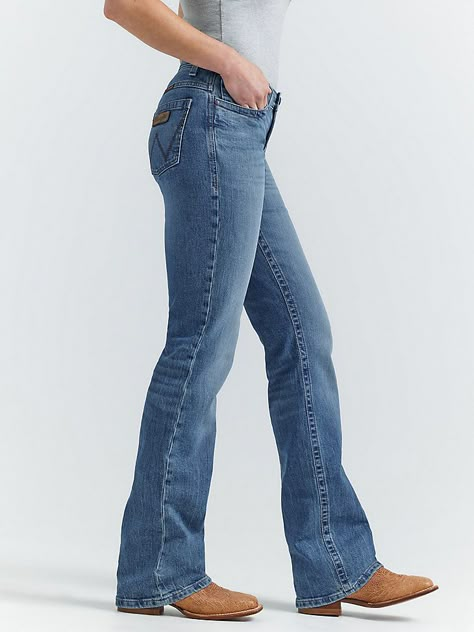 MADE FOR THE ULTIMATE RIDEAllow us to introduce you to Jade—part of the Women's Wrangler® Ultimate Riding Jean collection. This mid-rise relaxed bootcut jean for women is made of a comfortable cotton blend with stretch to keep up with riding, showing, and working. It's enhanced with a slightly pitched waistband that sits lower in the front and higher in the back for maximum comfort and coverage in the saddle as well as our signature no-gap waistband and flat comfort seams. The fit is a little looser for enhanced comfort. It comes with our signature five-pocket styling and "W" embroidery for marks of authenticity. Affordable Bootcut Jeans, Jeans And Boots Women, Petite Bootcut Jeans, High Waisted Bootcut Jeans Outfit, Western Jeans Womens, Flare Jeans Country, Wallpaper Western, Wrangler Jeans Women's, Wrangler Clothing