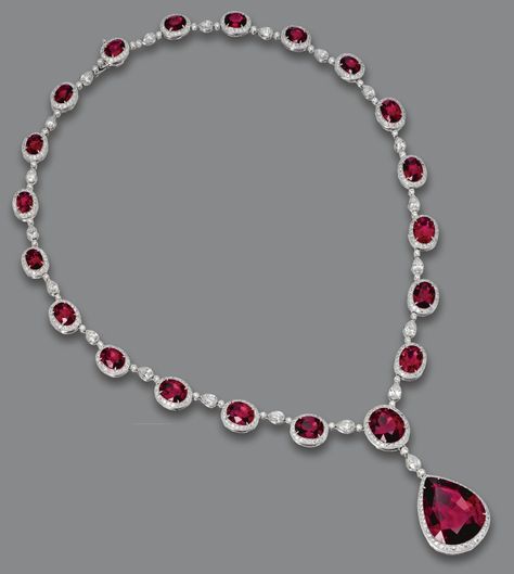 RUBELLITE AND DIAMOND NECKLACE.  The graduating necklace composed of 20 oval rubellites weighing approximately 29.80 carats, the center supporting a pear-shaped rubellite weighing 21.77 carats, all within borders of 21 pear-shaped  diamonds and numerous round diamonds weighing a total of approximately 9.00 carats, mounted in platinum, length 16¼ inches. Solitaire Pendant Necklace, Diamond Jewelry Necklace, Ruby Jewelry, White Gold Jewelry, Pear Shaped Diamond, Red Ruby, Van Cleef, Gorgeous Necklaces, Turquoise Jewelry