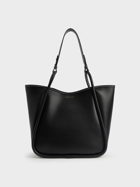 Elegance with a wear-anywhere appeal, this oversized tote bag is a must-have for any style-conscious minimalist. A sleek all-black finish is easy to incorporate into your wardrobe, while the roomy interior makes for ample storage space. If you need more, it also comes with a detachable inner pouch. Oozing versatile understated charm, this trans-seasonal tote bag will look brilliant with a patterned shift dress and flats for an effortless look. Black Work Bag, Charles And Keith Bags, Slouchy Tote Bag, Charles And Keith, Photographie Indie, Uni Bag, Circle Handle, Slouchy Tote, Canvas Totes