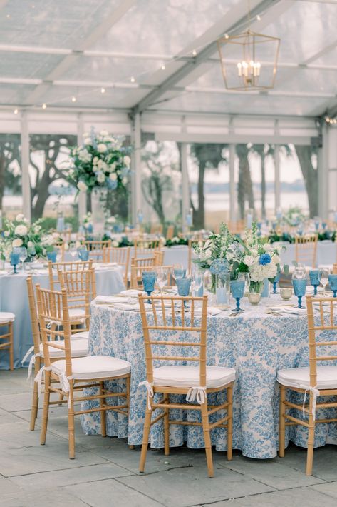 Blue floral table linens with tan chiavari chairs. Blue and white flowers. Navy And Carolina Blue Wedding, Blue And Rattan Wedding, Blue And White Tablecloth Wedding, Classic Blue Wedding Theme, Blue Navy Wedding Theme, Blues And White Wedding, Timeless Coastal Wedding, French Blue And Champagne Wedding, Blue And White China Wedding Decor