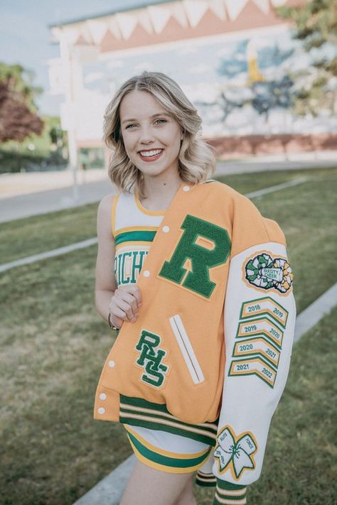 A cheerleader shows off her patches on her Varsity letterman jacket. She is on the richland high school campus. Varsity Jacket Cheerleader, Letterman Patches Ideas, Bedazzled Letterman Jacket, Letterman Photoshoot, Lettermen Jacket Ideas, High School Letterman Jacket Ideas, Cheer Letterman Jacket Ideas, Varsity Jacket Senior, Cheer Letterman Jacket