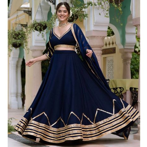 "✨Embrace the mystical allure of the night sky with Tarz's mesmerizing Blue Lehenga Choli, designed to captivate hearts and illuminate your sangeet night. Let the enchanting gotapatti lehenga cholis weave a tale of elegance, leaving everyone spellbound. 💫 💃Fabric details: 🥻LEHENGA: Georgette with glistening gotapatti embroidery #LENGTH: Upto 44\" #INNER: Soft buttercrepe #STRINGS AND ZIPPER: Ensuring the perfect fit 🥻BLOUSE: Elegant Georgette fabric #INNER: Comfortable buttercrepe #LENGTH: Customized to your measurements SIDE ZIP OPENING: For ease and convenience 🌸DUPATTA: Flowing Georgette fabric with a delicate border LENGTH: 2.5 meters of graceful beauty 🌟Shine like a star on your sangeet or cocktail night with Tarz's exclusive Bollywood-inspired lehengas.🌟 🌼Washing Instruction: Blue Designer Lehenga, Lace Lehenga, Dark Blue Lehenga, Choli Dress, Simple Lehenga, Trendy Outfits Indian, Indian Outfits Lehenga, Lehenga Designs Simple, Traditional Indian Dress