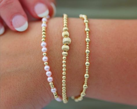 Waterproof | Tarnish Free | Hypoallergenic Bracelets: MELANIE ($49)- VICTORIA ($56)- ANGELINA ($46) Bead Material: Gold filled STRETCHY LENGTH: 6.5" OR 7" CLASP LENGTH: 6" + 1.5" EXTENSION High Performance Elastic Made in miami, made with love This stack is your ultimate accessory for effortless elegance and coastal chic. Inspired by the breezy sophistication of the Hamptons, these bracelets feature a collection of beautifully crafted ball beads in various sizes and colors, reminiscent of sun-ki Bracelets Stack, Gold Bracelets Stacked, Stack Bracelets, Preppy Bracelets, Preppy Jewelry, Coastal Charm, Jewelry Accessories Ideas, Gold Bead Bracelets, Rose Gold Pendant