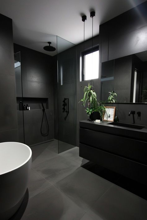 Modern bathroom with a freestanding bathtub, dark tiles, and a glass shower. Black And Grey Bathroom Ideas, Dark Modern Bathroom, Black And Grey Bathroom, All Black Bathroom, Grey Bathroom Ideas, Kitchen Wallpaper Ideas, Black Modern House, Black Modern Bathroom, Grey Bathroom Decor