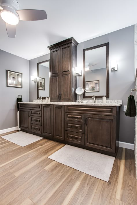 Vanity with two sinks, a tower, and extra storage. Double Sink Bathroom Vanity With Tower, Vanities With Towers, Bathroom Vanity Center Tower, Master Bath Vanity Ideas Double Sinks With Tower, Bathroom Vanity With Center Tower, Double Vanity Storage Tower, Vanity Storage Tower Double Sinks, Brown Bathroom Vanity Ideas, Bathrooms With Dark Cabinets