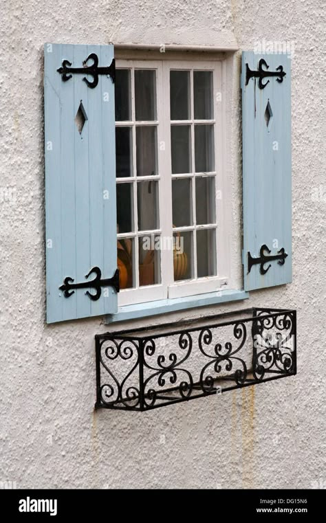 Download this stock image: window with light blue wooden shutters and wrought iron window box at Lyme Regis, Dorset UK in August - DG15N6 from Alamy's library of millions of high resolution stock photos, illustrations and vectors. Light Blue Shutters, Jendela Vintage, Outdoor Window Shutters, Wrought Iron Window Boxes, Wrought Iron Window, درابزين ا�لسلم, Window Shutters Exterior, Outdoor Shutters, House Shutters