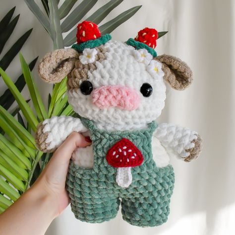 pattern: @crochetcalls🌱 The cottagecore cow🐮🍄🌱✨🍓🌼 I’ve been getting a lotttt of questions on how I created this cottagecore cow, here’s how! Where to find the pattern: This cow is made combining my strawberry cow pattern & my cherry blossom mod🍓🌸 both of these patterns are available in my 10-in-1 fruit cow set on my Etsy only! The mushroom appliqué is a free pattern on YouTube by Pora Pora Crochet🍄 What yarn was used: I used bernat blanket yarn for the cow & chenille home slim for the over... Crochet Patterns Chenille Yarn, Crochet Mushroom Blanket Pattern Free, Crochet Mushroom Ideas, Bernat Blanket Amigurumi, Crochet Strawberry Animals, Chenille Amigurumi Free Pattern, Strawberry Cow Crochet Pattern Free, Mushroom Cow Crochet, Free Crochet Mushroom Pattern