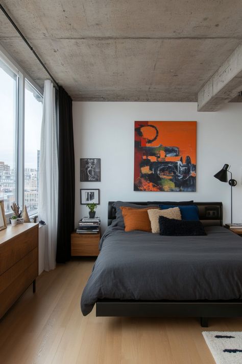 Modern bedroom with a dark gray bed, colorful abstract art, and large window. Men’s Minimalist Apartment, Minimal Male Bedroom, Minimal Men Bedroom, Men’s Bedroom Minimalist, Men’s Cozy Bedroom, Apartment Bedroom Minimal, Guy Apartment Bedroom, Minimal Mens Apartment, Simple Male Room Ideas