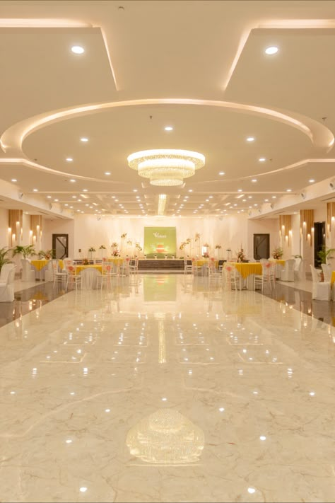 The Main entrance opens up to a grand banquet hall which is a dedicated ritual area for Indian ceremonies, a pillar-free ballroom with a 14 ft high ceiling for the perfect wedding ambience. The interiors of the main hall were designed around the ceiling. Ceiling Design Banquet Hall, Banquet Hall Floor Tiles Design, Birthday Party Hall Interior Design, Wedding Halls Designs, Wedding Hall Background, Marriage Hall Ceiling Design, Wedding Hall Design Interior, Banquet Hall False Ceiling Design, Event Interior Design