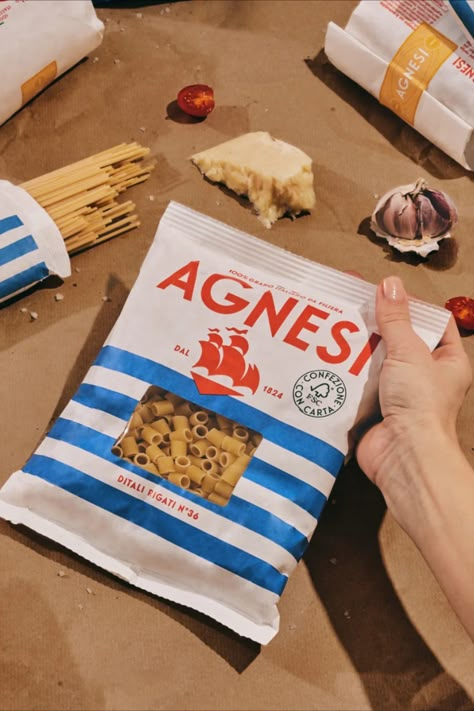 One of the most recognizable supermarket pasta brands is celebrating its 200th anniversary with a charming upgrade from Auge Design. Agnesi's nautical new look is super fitting of the Italian company's lengthy legacy, but also has enough retro-modern charm that we could imagine it popping up in a Wes Anderson movie (which is definitely a thing right now). Pasta Packaging Photography, Italian Packaging Design, Italian Food Packaging, Pasta Branding, Pasta Packaging Design, Supermarket Branding, Italian Packaging, Pasta Design, Pasta Packaging