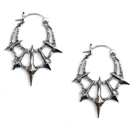 Add some gothic style to your wardrobe with these unique Chaos Earrings. Made in sterling silver, these earrings feature 5 spikes contrasted by a heavy textured crescent. Dimensions These earrings are 45mm long x 36mm wide and 5mm thick Each earring weighs approximately 6.5grams Punk Ear Piercings, Grunge Jewelry Earrings, Spike Accessories, Earrings Reference, Alt Earrings, Alt Jewelry, Spiked Jewelry, Edgy Earrings, Goth Earrings