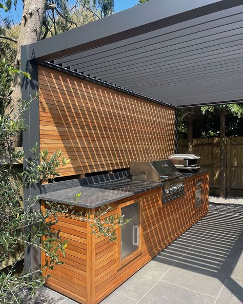 A modern masterpiece for alfresco dining and entertaining! 🤩 What’s your dream outdoor kitchen feature? A BBQ, pizza oven, or something else entirely? Let us know in the comments! 👇🏼 Designed & created by @greatescapegarden 👏🏼 Pergola For Bbq Area, Bbq Tile Ideas, Outdoor Patio Ideas Bbq, Outdoor Covered Bbq Area, Undercover Bbq Area, Outdoor Kitchen Dining Area, Bbq Kitchen Outdoor Grill Station, Bbq Pizza Oven Outdoor Area, Affordable Outdoor Kitchen Ideas