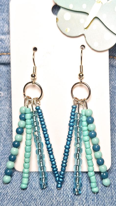 These handmade beaded earrings in varying shades of blue effortlessly dangle, making a striking statement piece. Perfect as a unique gift. Diy Jewelry Making Earrings, Beaded Statement Earrings, Evil Eye Earrings Diy, Beaded Jewelry Ideas Handmade, Beaded Earring Designs, Earring Making Ideas, Home Made Earrings, Beaded Earring Patterns, Cute Beaded Earrings