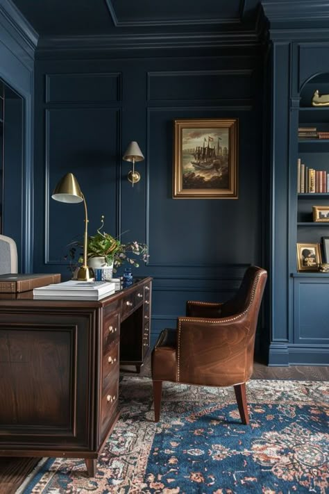 Dark blue walls and gold accents throughout bring a luxurious feel to this office. Dark wood furniture and a plush area rug add warmth and texture, making the space both elegant and comfortable. Navy Blue And Wood Office, Dining Room Aesthetic Dark, Dark Dining Room Walls, Dark Dining Room Table, Dark Wood Interior Design, Dark Dining Room Ideas, Moody Office Ideas, Dark Blue Office, Room Aesthetic Dark