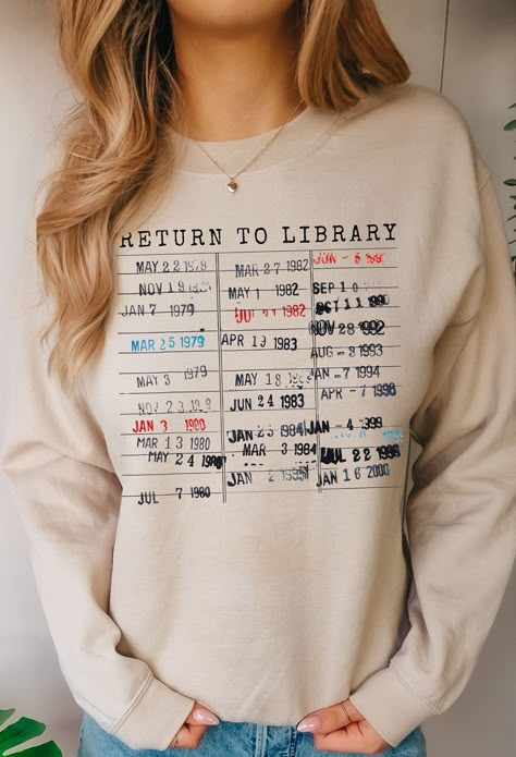 Return to the library--always! The perfect subtle bookish look, this vintage book due date stamp shirt would make a great gift for readers, authors, and book lovers alike. The neutral shirt is available as a crewneck sweatshirt or t-shirt; both come in unisex sizing for women and men. Booktopia Gifts designs for readers, writers, and book lovers. As an author myself, I want to be surrounded by bookish things in all forms! Any design in our shop can be placed on mugs, women's & men's shirts and s Library T Shirts, Book Lovers Shirts, English Teacher Shirts Designs, Book Shirt Ideas, Bookworm Outfits, Unisex Gift Ideas For Adults, Library Sweatshirt, Bookish Tees, Bookish Clothes