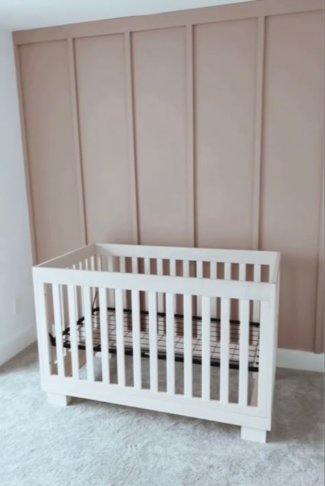 A photo of a board and batten accent wall in the color insightful rose by sherwin Williams as an accent wall in a nursery room for a baby girl Light Pink Nursery Accent Wall, Long Board And Batten Wall, Vertical Wood Accent Wall Nursery, Nursery Accent Wall Color, Mauve Pink Accent Wall, Cabbage Rose Sherwin Williams Nursery, Blush Board And Batten Wall, Mauve Shiplap Wall, Rose Colored Nursery