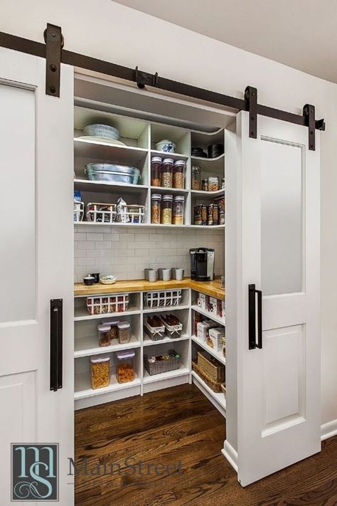 A large walk-in pantry sits behind a modern rolling barn door. It includes plenty of custom open shelving and a functional butcher block countertop. Walk In Pantry Ideas Layout, Walk In Pantry Ideas, Barn Door Pantry, Pantry Layout, Open Pantry, Dream Pantry, Modern Pantry, House Pantry, Cabinet Pantry