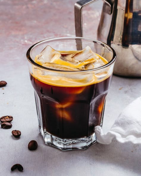 The Iced Americano is a refreshing, bold and bitter coffee drink! Here's what it is and a recipe for how to make it at home. #americano #icedamericano #coffee #coffeedink #icedcoffee #icedespresso #starbucksdrink French Press Iced Coffee, Americano Recipe, Cozy Coffee Aesthetic, Energy Drink Recipe, Iced Caramel Macchiato, Iced Cappuccino, A Couple Cooks, How To Make Ice Coffee, Iced Americano