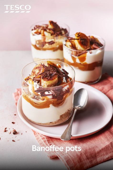 These banana trifle pots have big banoffee vibes. Top crumbled biscuits with whipped cream, caramel sauce, and sliced banana. They’re ready in just 20 minutes – perfect for when you’re craving something sweet. | Tesco Banoffee Parfait, Hygge Baking, Banoffee Trifle, Banoffee Pudding, Mini Trifle Desserts, British Cakes, Mini Trifles, Banana Trifle, Sweet Drinks Recipes