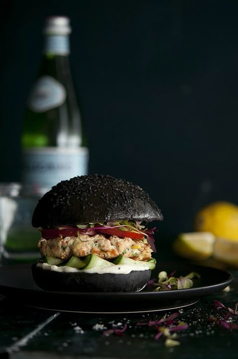 Squid Ink Sal­mon Burger       When I was in Lis­bon this year I tasted the most amaz­ing thing: a squid ink sal­mon bur­ger. Not only did it look freakin’ cool it tasted even bet­ter. The squid ink is subtle, yet com­pletely notice­able and integ­ral. The fla­vour, which I can only describe as being “the sea’ or hav­ing a ‘seaness’ trans­forms a simple sal­mon bur­ger into a fant­ast­ical delight – there really is some­thing quite fun in eat­ing a black burger.     The squid ink com­pli­me... Black Burger, Unique Burgers, Salmon Burger, Salmon Patties Recipe, Dark Food, Black Food, Burger Buns, Burgers Sandwiches, Wrap Sandwiches