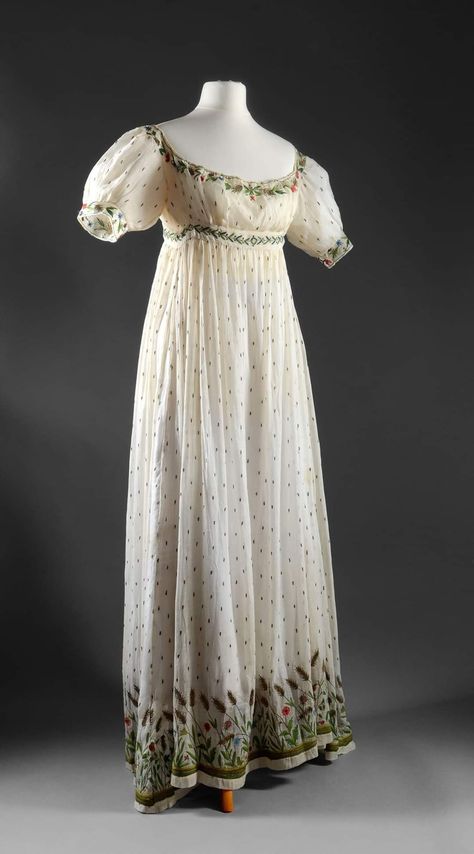 Dress, Empire period, 1800/1820  High-waisted, low-cut dress with small puffed sleeves in Indian cotton muslin embroidered with polychrome silk in Beauvais stitch and gold thread with a sowing of leaves and on the bottom of a wide band of gold wheat ears interspersed with poppies and blue carnations; adjoining stapled belt highlighted with a myrtle frieze. Source:Coutau-Bégarie Regency Period Dress, Bridgerton Ball, Empire Line Dress, Empire Style Dress, 19th Century Dress, Coronation Robes, Historical Gowns, Blue Carnations, Historical Sewing