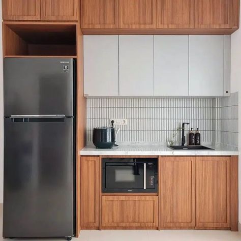 This kitchen’s dark cabinets bring in a cozy vibe, and they contrast nicely with a cool dark gray fridge. Image credit: INSTAGRAM @FADHILAHAKBR Cabinets Around Fridge, Single Wall Kitchen, Cabinet Fridge, Fridge Cabinet, One Wall Kitchen, Kitchen S, Pantry Wall, Kitchen Fridges, Compact Kitchen